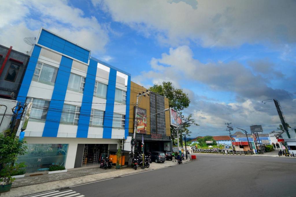 日惹的住宿－RedDoorz Plus @ Terban Residence，街道边的蓝色和白色建筑