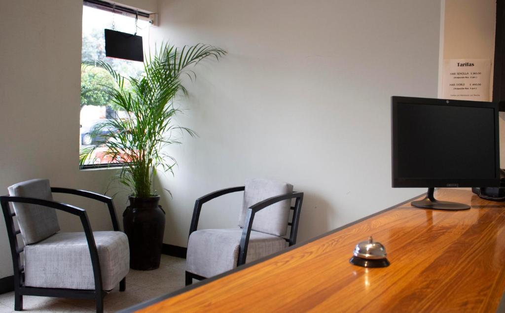 Tlaxcala de Xicohténcatl的住宿－Hotel Winn Comfort，一张桌子、一台电视和两把椅子