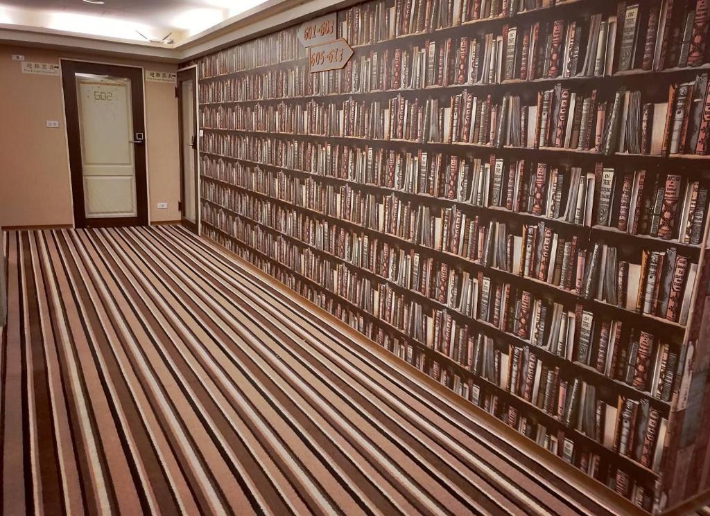 a library with a wall full of books at Sanduo Hotel in Kaohsiung