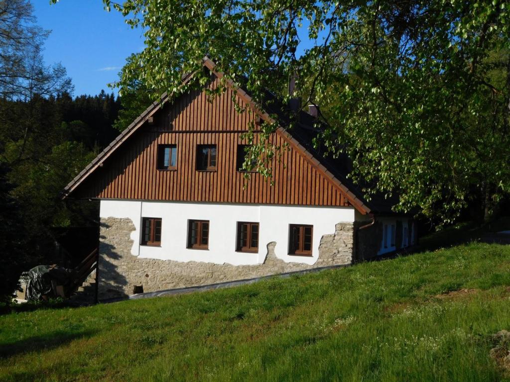 uma casa branca com um telhado vermelho numa colina em Chalupa U sjezdovky, Zadov 22 em Stachy
