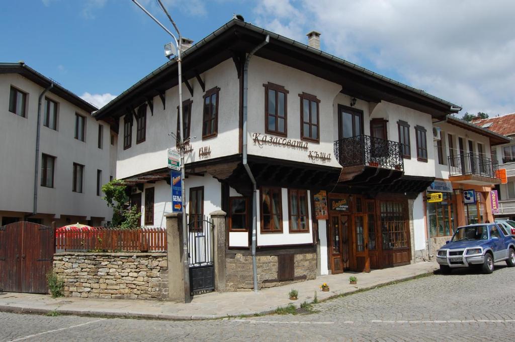 a building on a street with a car parked in front at Kazasovata Guest House in Tryavna
