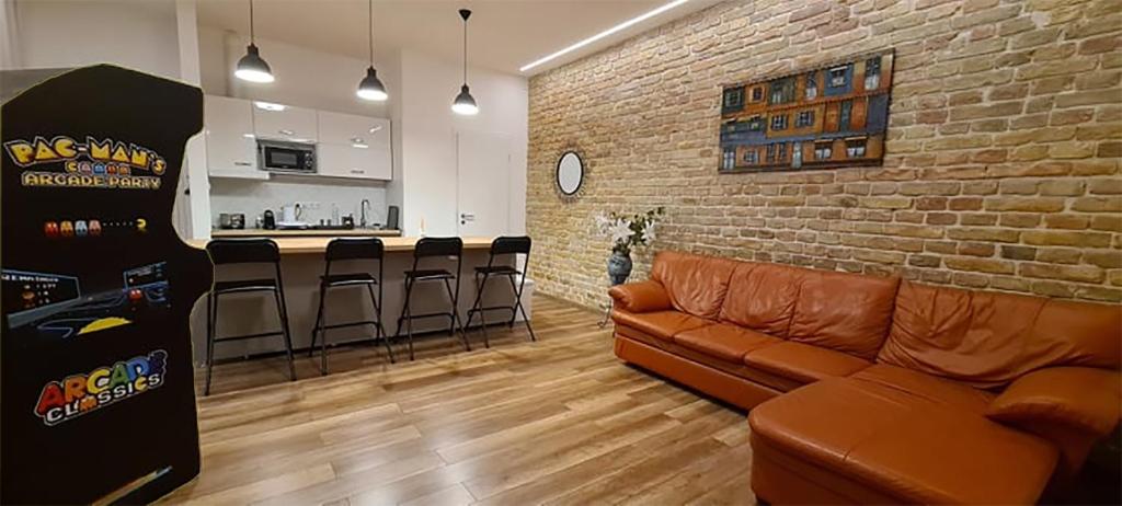 a living room with a couch and a brick wall at Pacman Apartment in Budapest