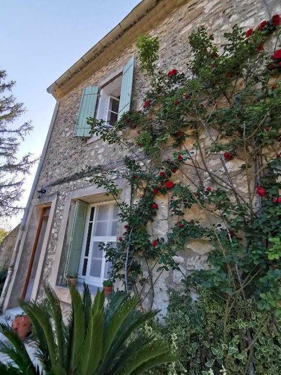 une maison en pierre avec des fleurs sur son côté dans l'établissement Mas de Férigoulet -