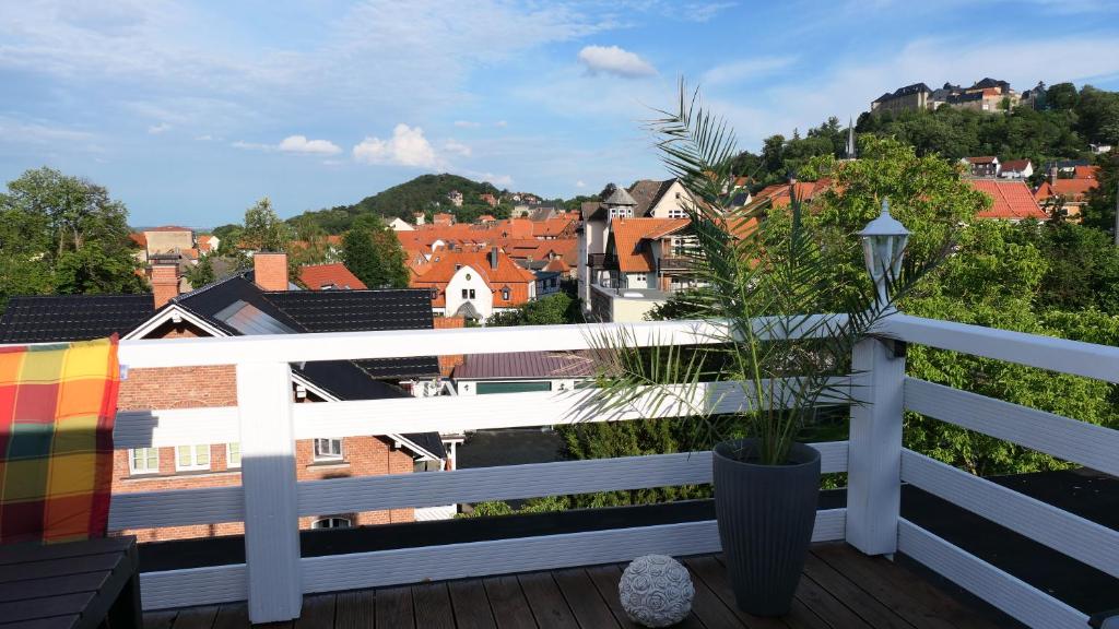 a balcony with a potted plant and a city at Über den Dächern in Blankenburg
