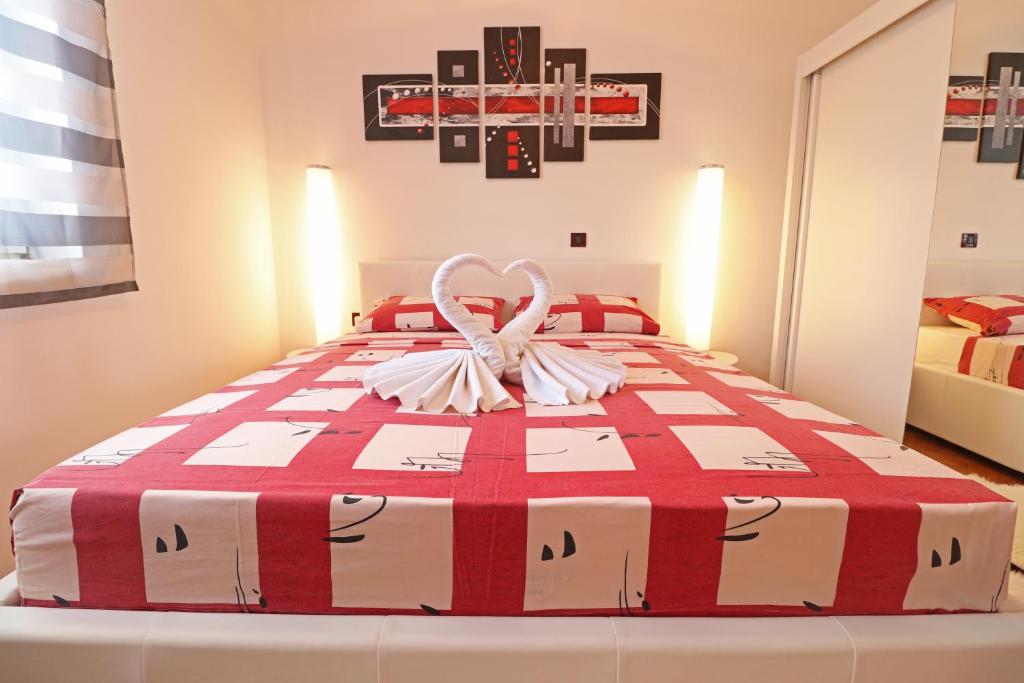 a bedroom with a large bed with a red and white blanket at Apartments Medulin - Orijeta in Medulin