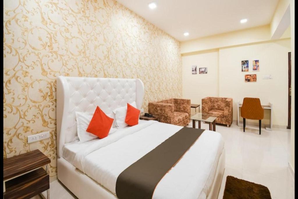 a hotel room with a bed and a desk and chairs at Hotel Golden - I in Raipur