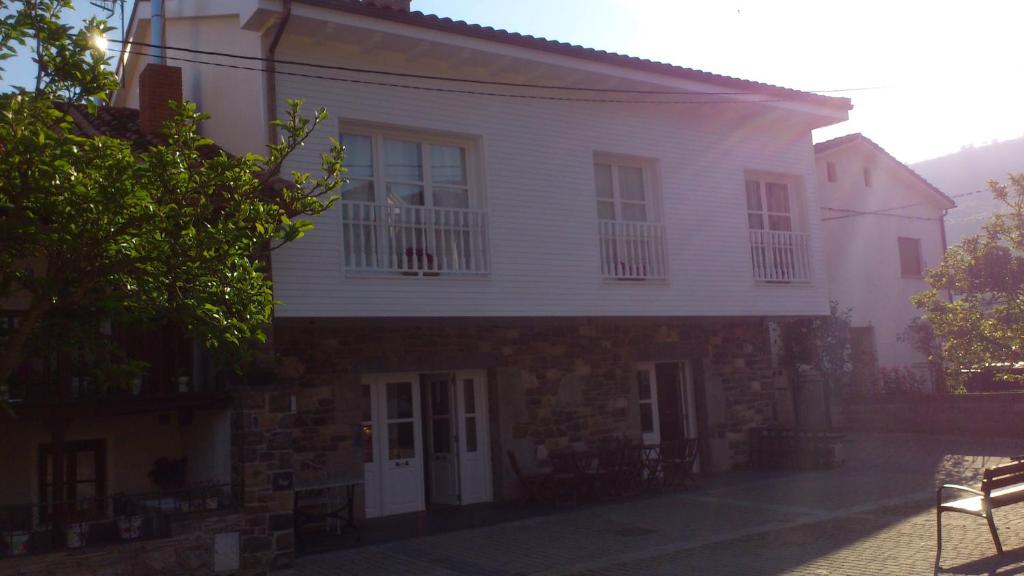 una casa blanca con un banco delante en Hotel Rural El Secreto de Julia en Ríoseco