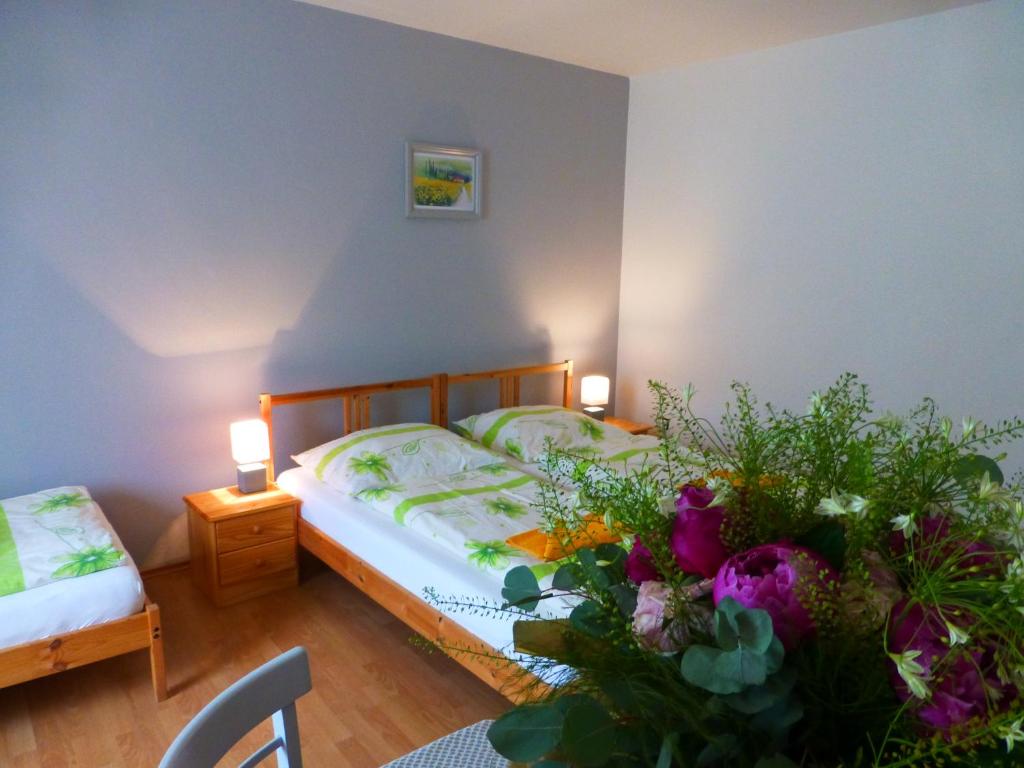 a bedroom with a bed and a table with flowers at Ubytovanie na Frantšachte in Banská Štiavnica