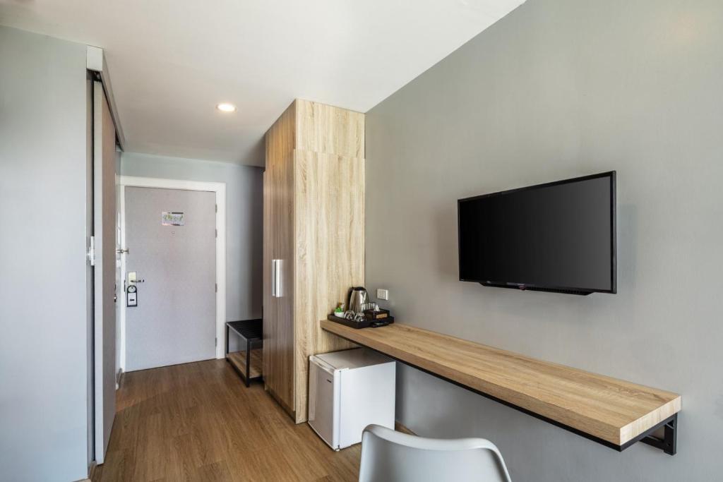 A wall-length hotel desk and television occupy one side of the room.
