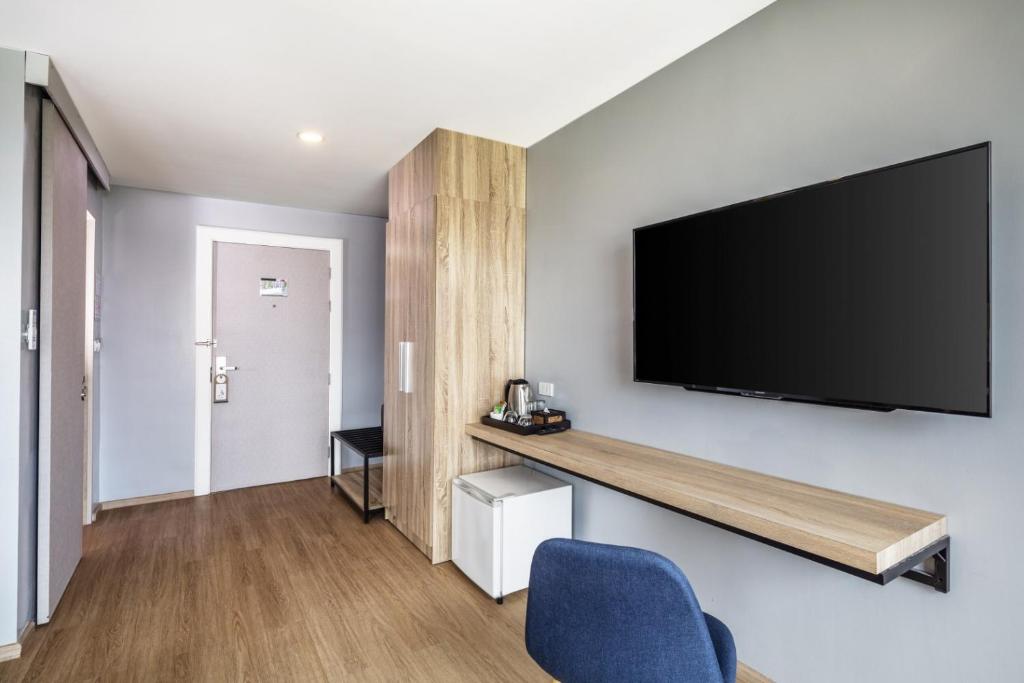 A wall-mounted television above a long desk beside the room entrance.