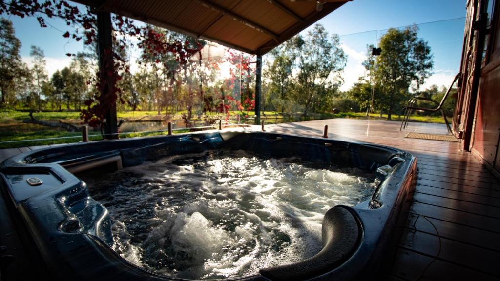 a hot tub with water in it on a patio at Carriages Spa Retreat in Echuca
