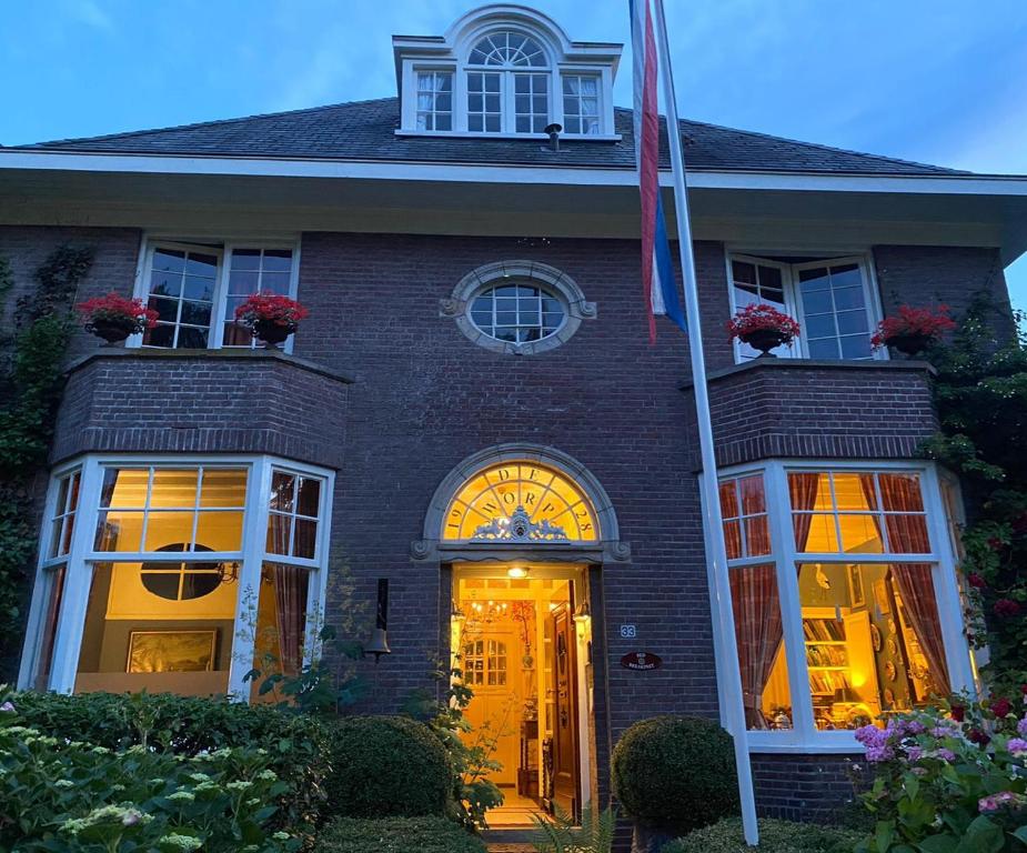 a white house with a red door and windows at Deventer Heritage en Boutique B&B museumhuis Huize "De Worp" in Deventer