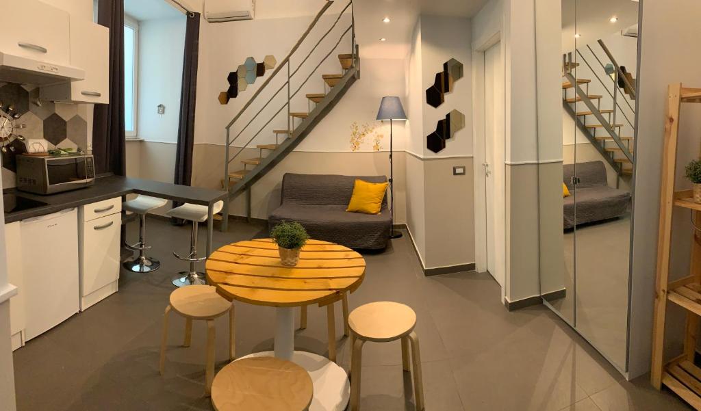 Una cocina y una sala de estar con mesa y sillas. en Little Dream Residenza - Napoli, en Nápoles