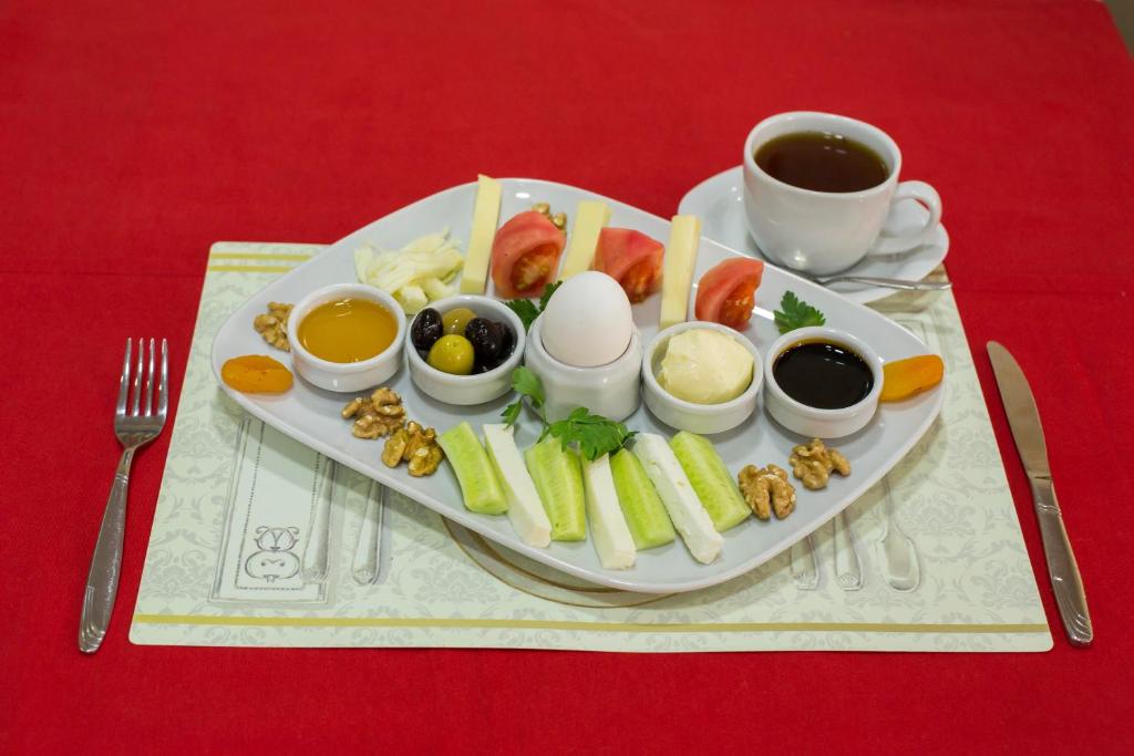 un piatto di alimenti con uova e altri alimenti e una tazza di caffè di İHVA HOTEL PİERRELOTİ a Istanbul