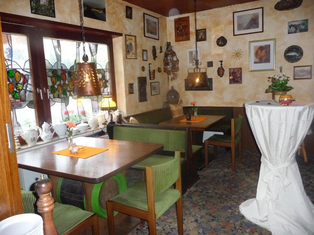 ein Restaurant mit Tischen und Stühlen in einem Zimmer in der Unterkunft Hotel-Garni-Sonnenlay in Bernkastel-Kues