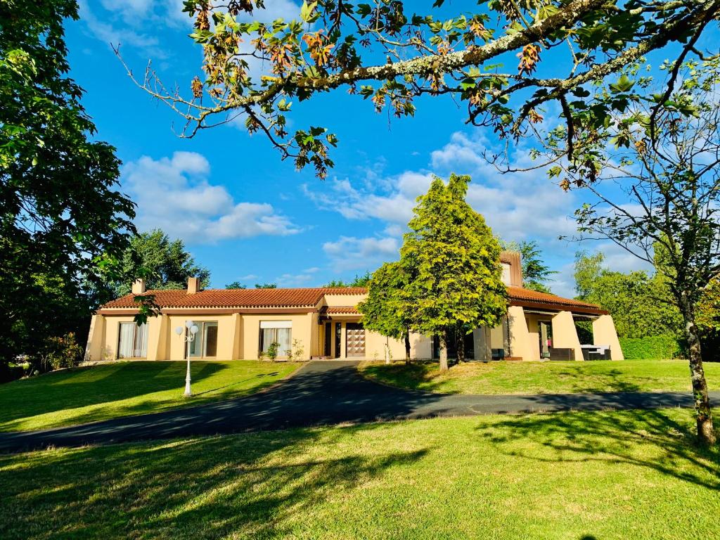 una casa con un árbol delante de ella en Villa du Bois Verts en Les Herbiers