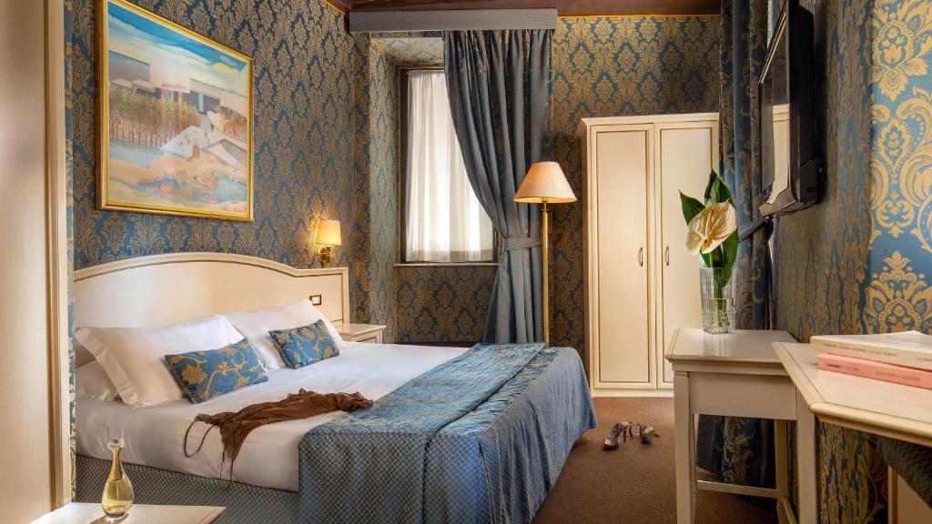 a bedroom with a bed in a room with blue wallpaper at Residenza Canova Tadolini - Guesthouse in Rome