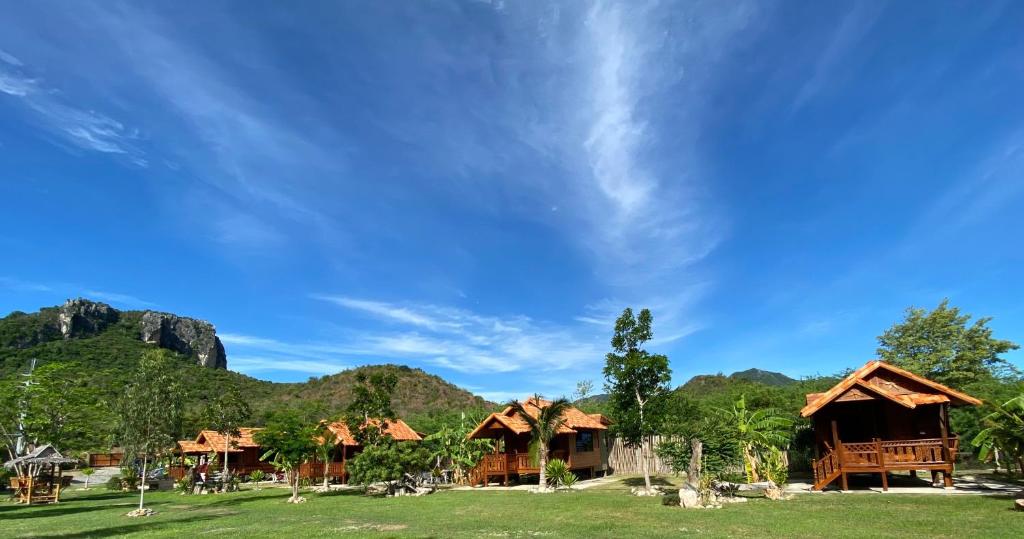 a group of cottages with mountains in the background at Jing Jo Boutique Bungalow in Sam Roi Yot