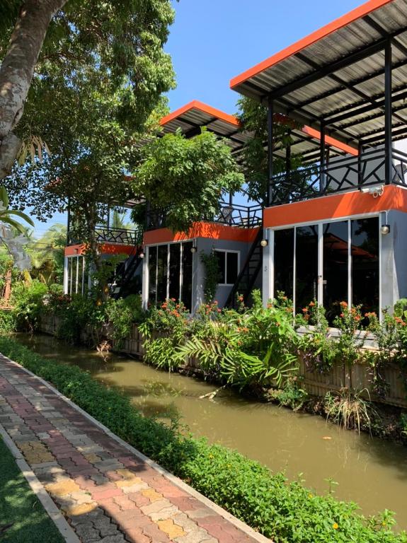 a building with a pond in front of it at Meephawa Resort in Amphawa