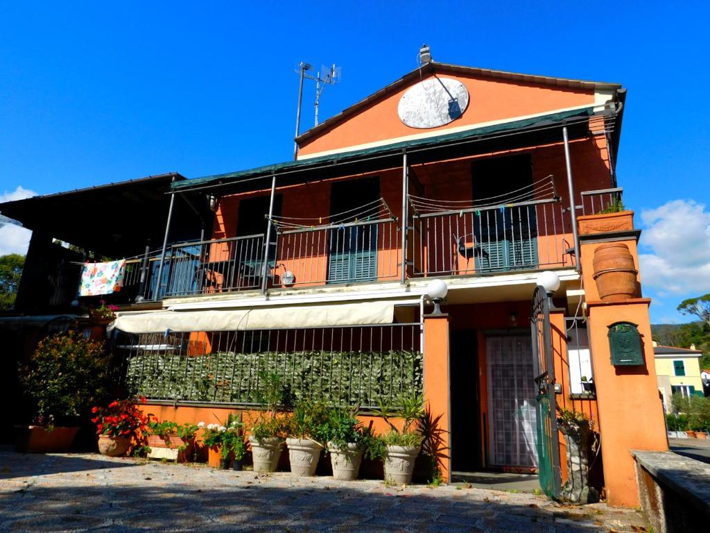 ein orangefarbenes Gebäude mit Topfpflanzen davor in der Unterkunft La casa rosa! in Levanto