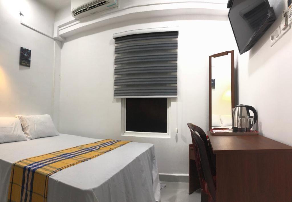 sypialnia z łóżkiem, biurkiem i lustrem w obiekcie WISH RESIDENCE SEASIDE Colombo3 w Kolombo