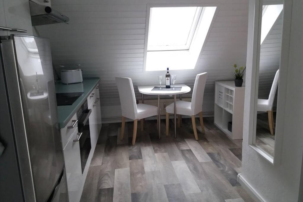 cocina con mesa, sillas y ventana en Helle 2-Zimmerwohnung am Stadtrand, en Hildesheim