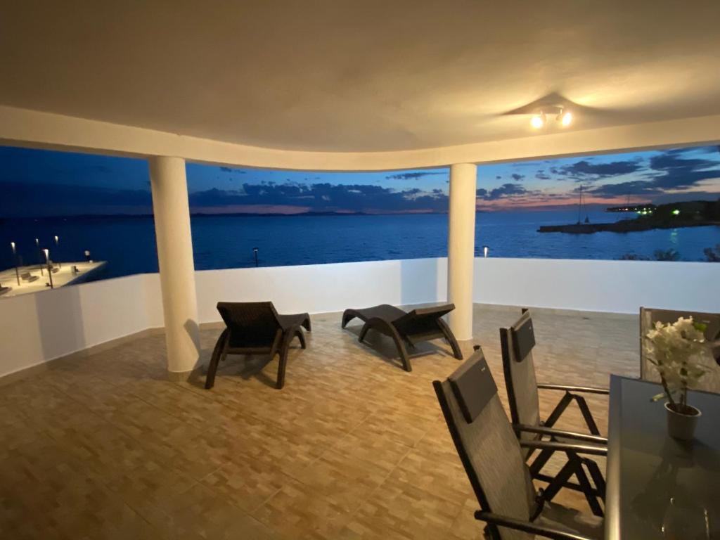 a room with chairs and a view of the ocean at Villa Magia sul Mare in Petrcane
