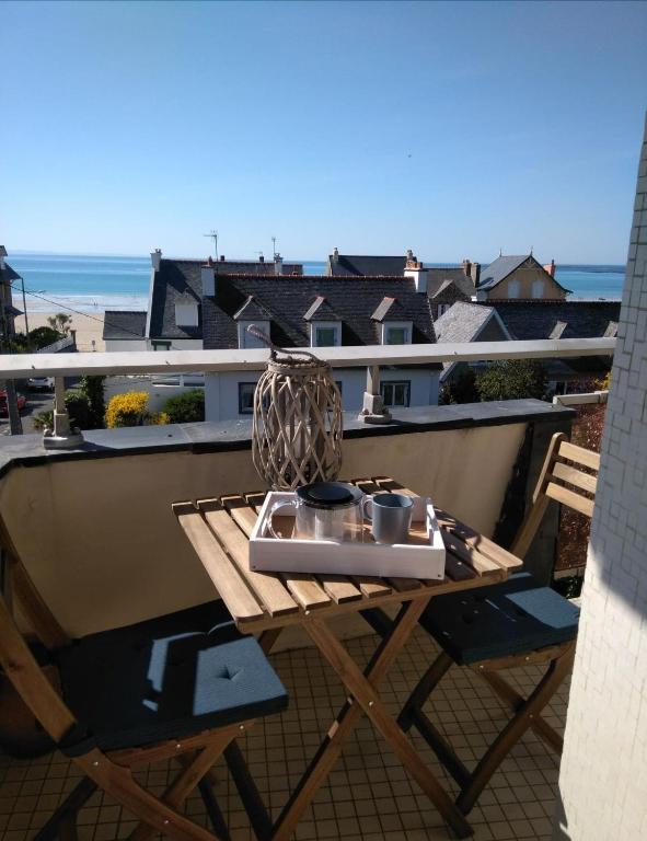 - une table sur un balcon avec vue sur l'océan dans l'établissement Le Sterne, à Pléneuf-Val-André