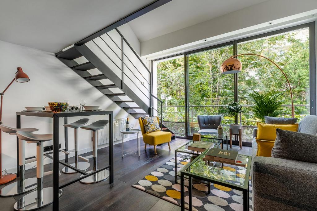 - un salon avec un escalier et des chaises jaunes dans l'établissement B5 Loft Duplex 175Blo-Paris Convention, à Paris