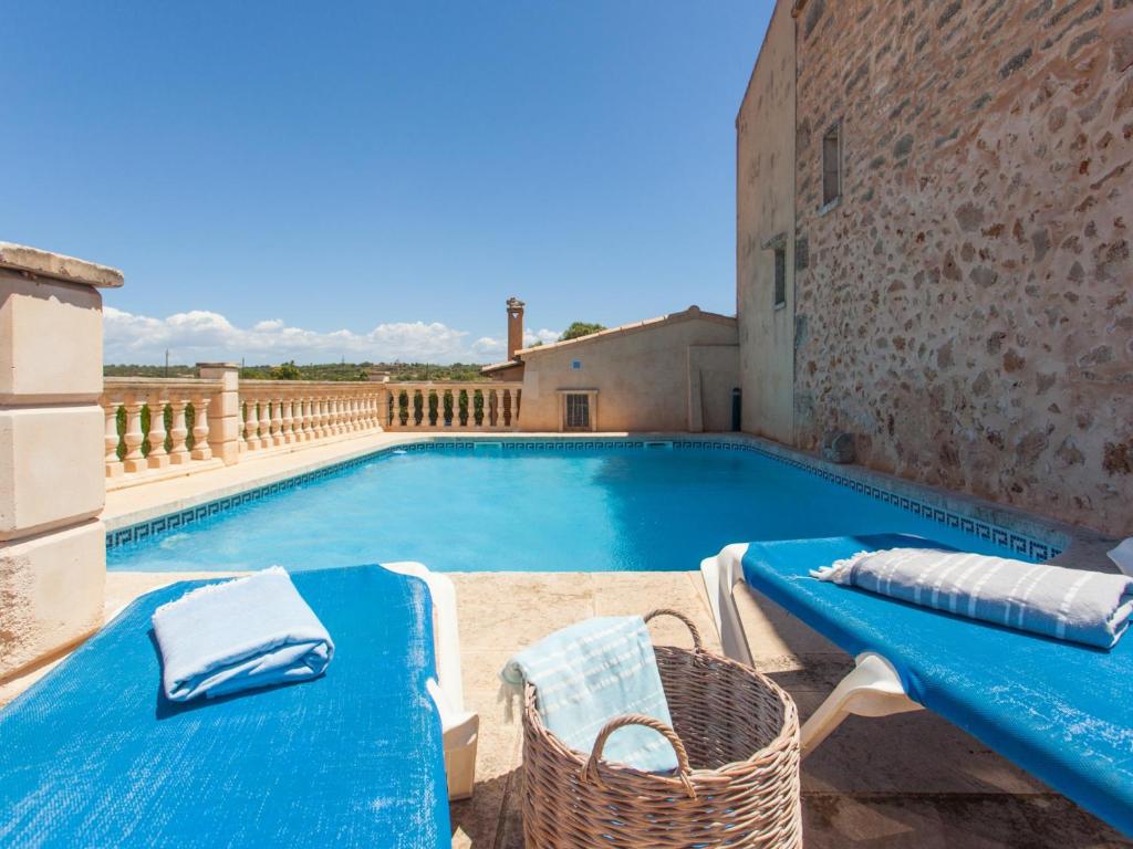 una grande piscina con tavolo e sedie blu di Na frare casa de campo a Ses Salines