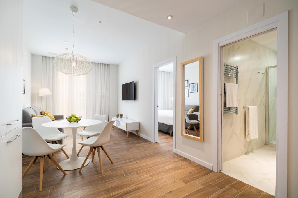 a dining room and living room with a table and chairs at Tandem Puerto Chico in Cádiz