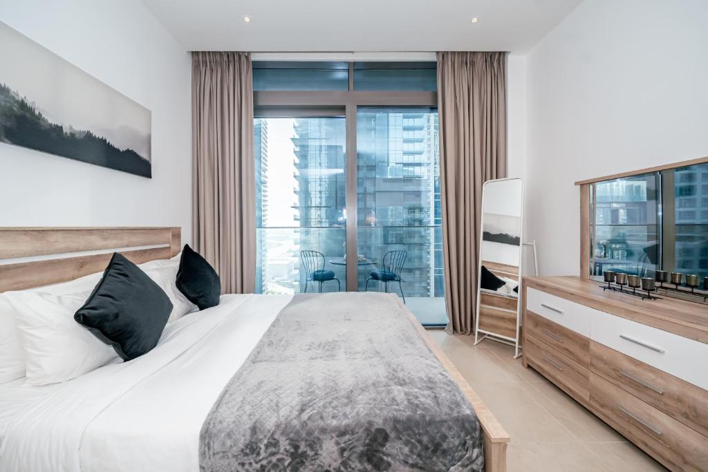 a bedroom with a large bed and a large window at HiGuests - Unique Studio With Stunning Panoramic Marina Views in Dubai