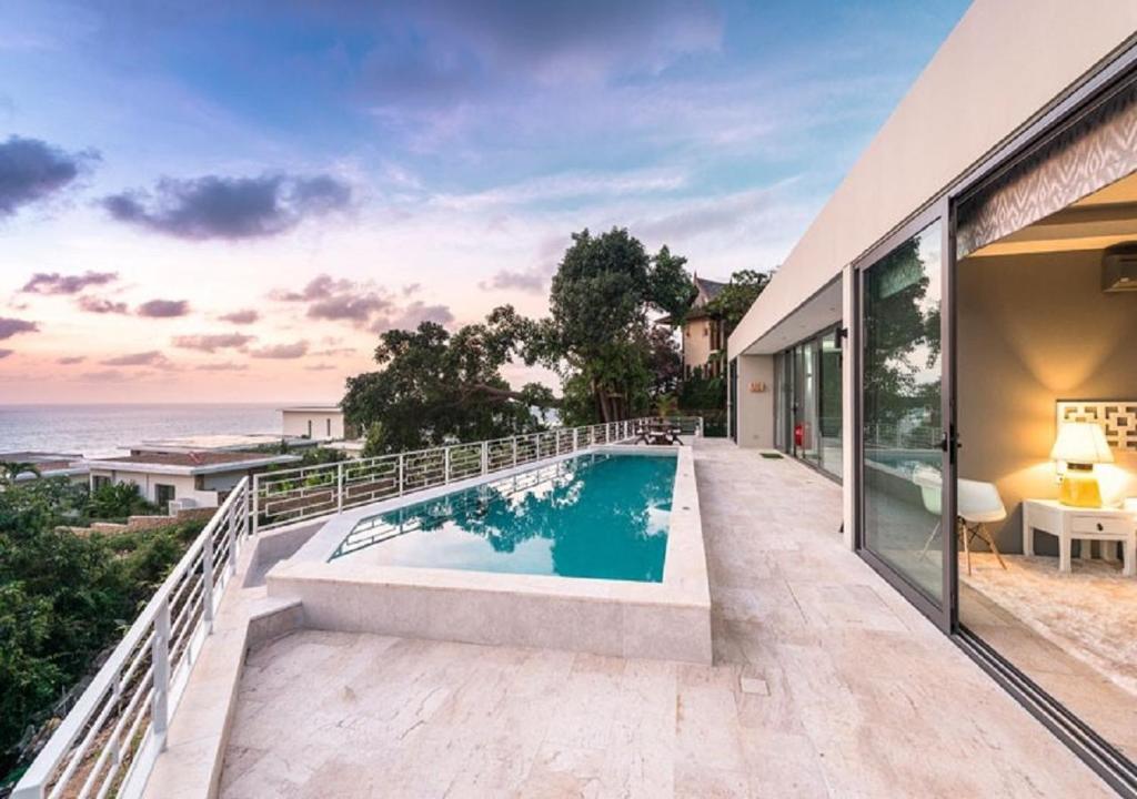 une maison avec une piscine et l'océan dans l'établissement Sasha Villa, à Choeng Mon Beach