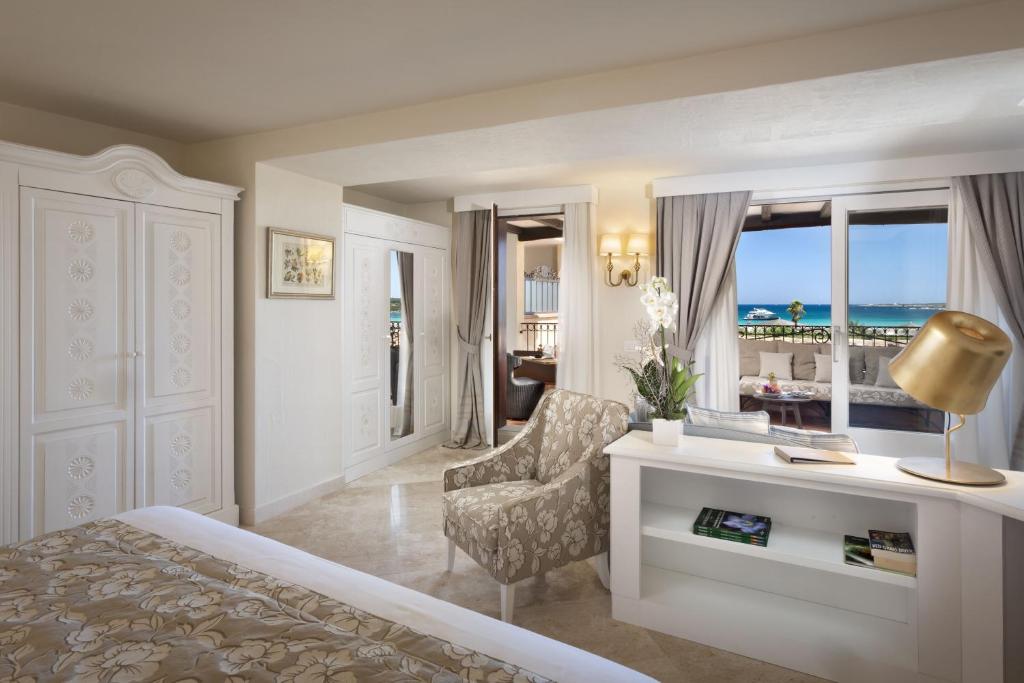 a bedroom with a bed and a desk and a chair at Hotel Abi d'Oru in Porto Rotondo