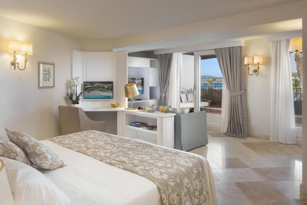 a hotel room with a bed and a large window at Hotel Abi d'Oru in Porto Rotondo