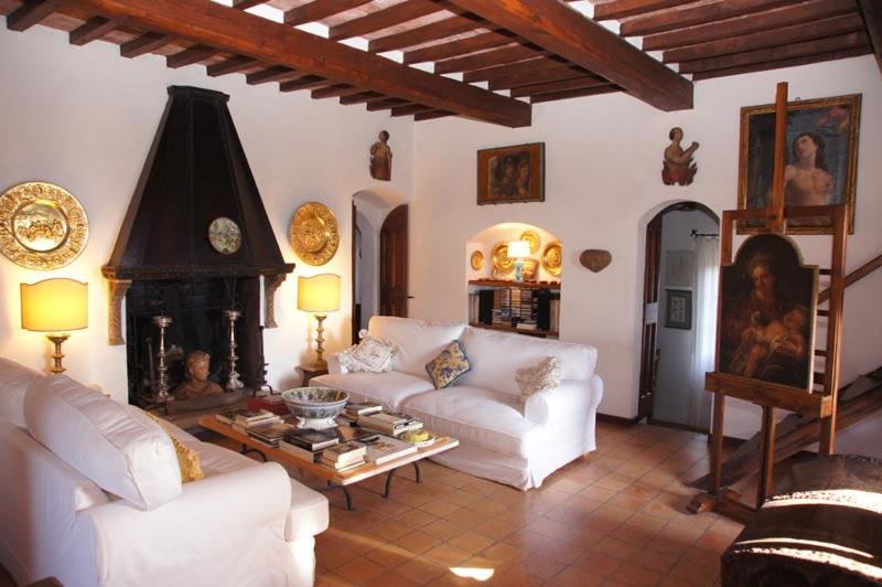 a living room with white couches and a fireplace at Alloggio Castello di Loreto in Todi