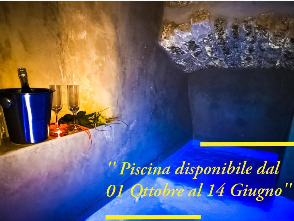 um quarto azul com uma garrafa de vinho numa prateleira em Suite Mazzini con piscina em Ostuni