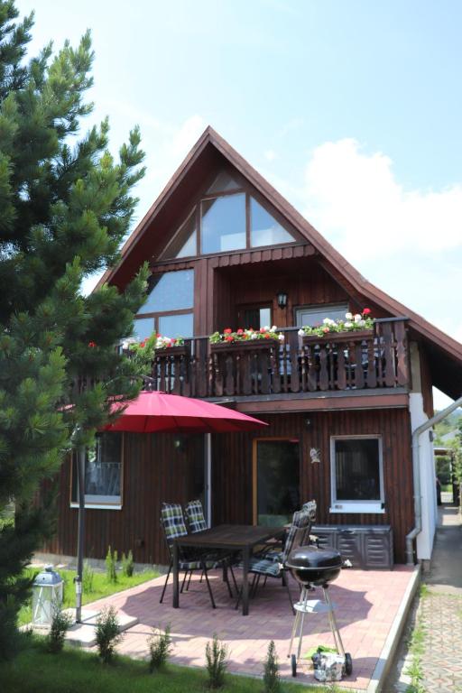 ein Haus mit einer Terrasse mit einem Tisch und Stühlen in der Unterkunft Ferienhaus Geli in Wernigerode