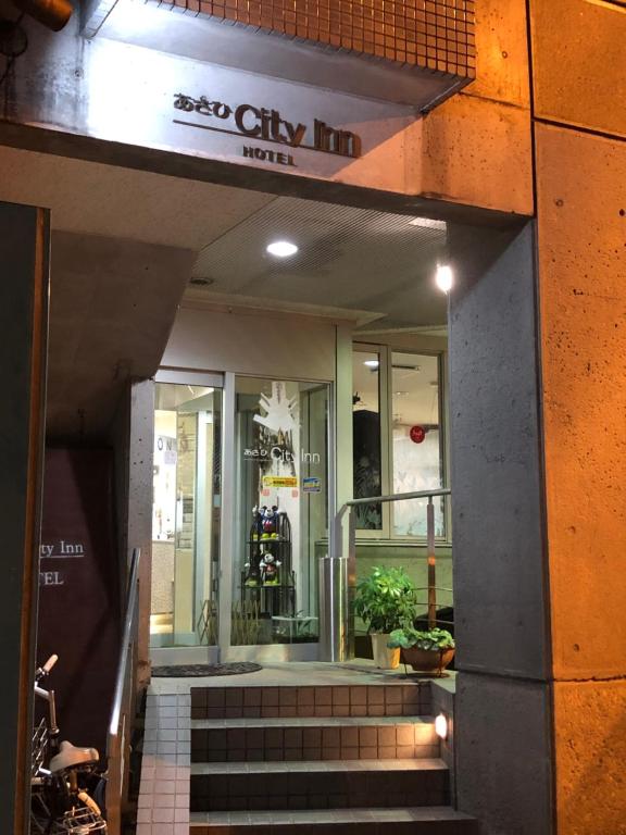 a store front with stairs in front of a building at Asahi City Inn Hotel in Takaoka