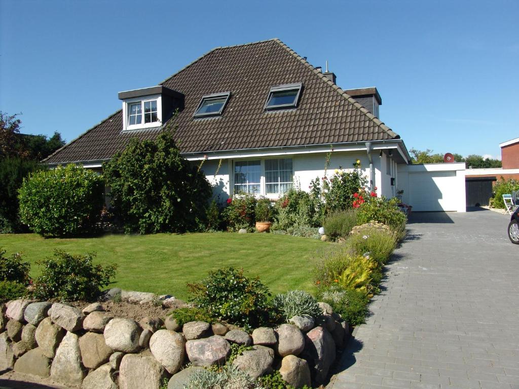 uma casa com uma parede de pedra em frente a um quintal em Norderpiep em Büsum