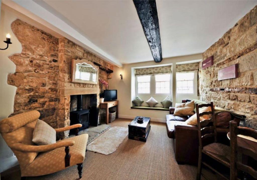 a large living room with a stone wall at Thornton in Chipping Campden