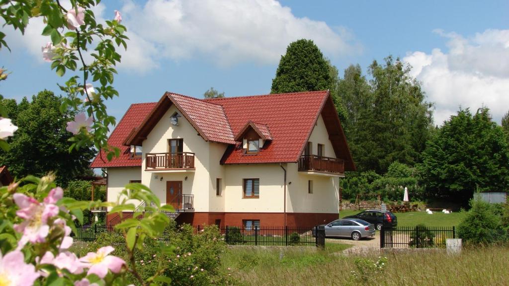una casa con techo rojo en Słoneczna Ostoja, en Mikołajki