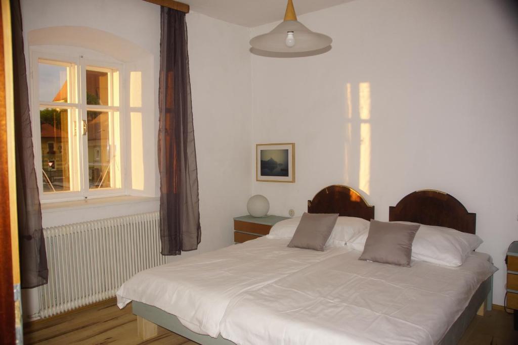 un letto bianco in una stanza con finestra di Vintage 2 Ferienwohnung für 2-3-4 a Schörfling am Attersee