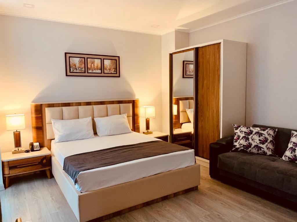 バトゥミにあるHotel Tsereteli Palaceのベッドルーム(ベッド1台、ソファ付)