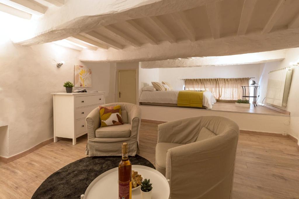 a living room with a bed and a table and chairs at Il Cuore di Chiusi - Autentica Casa in Toscana in Chiusi