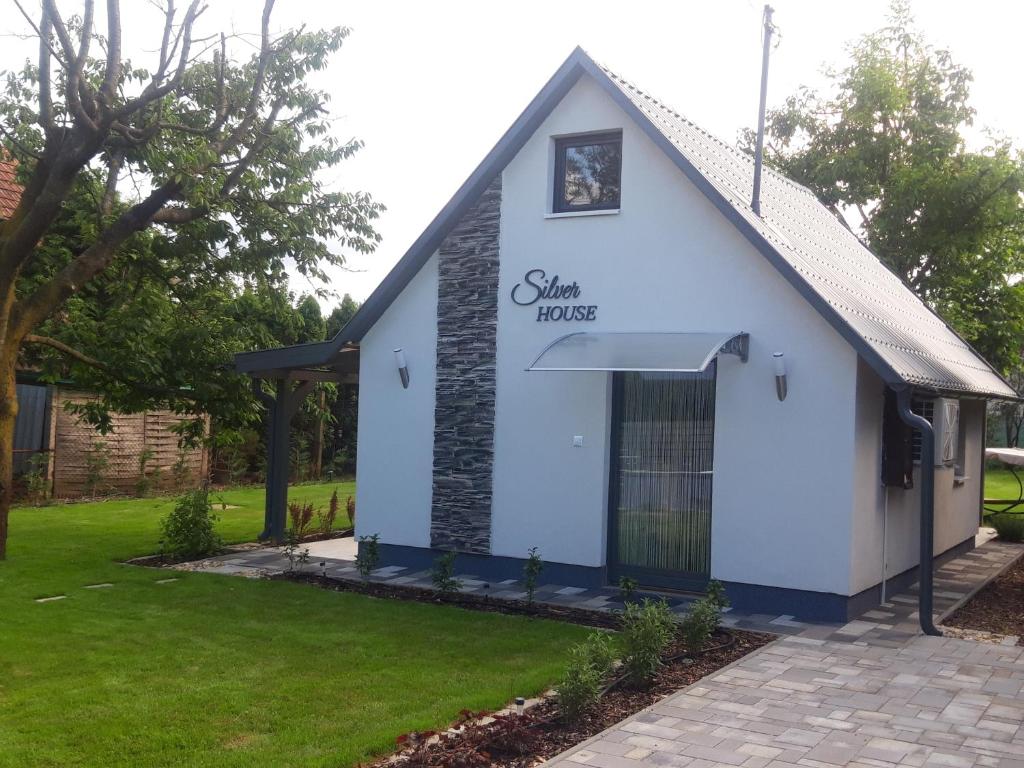 a white building with a sign that reads shaney house at Silver House vendégház in Orosháza