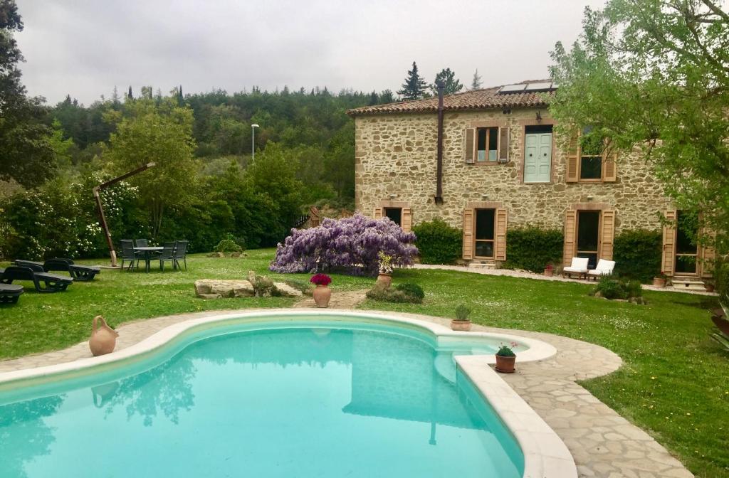 una piscina di fronte a una casa in pietra di Casa sul Monte a San Venanzo