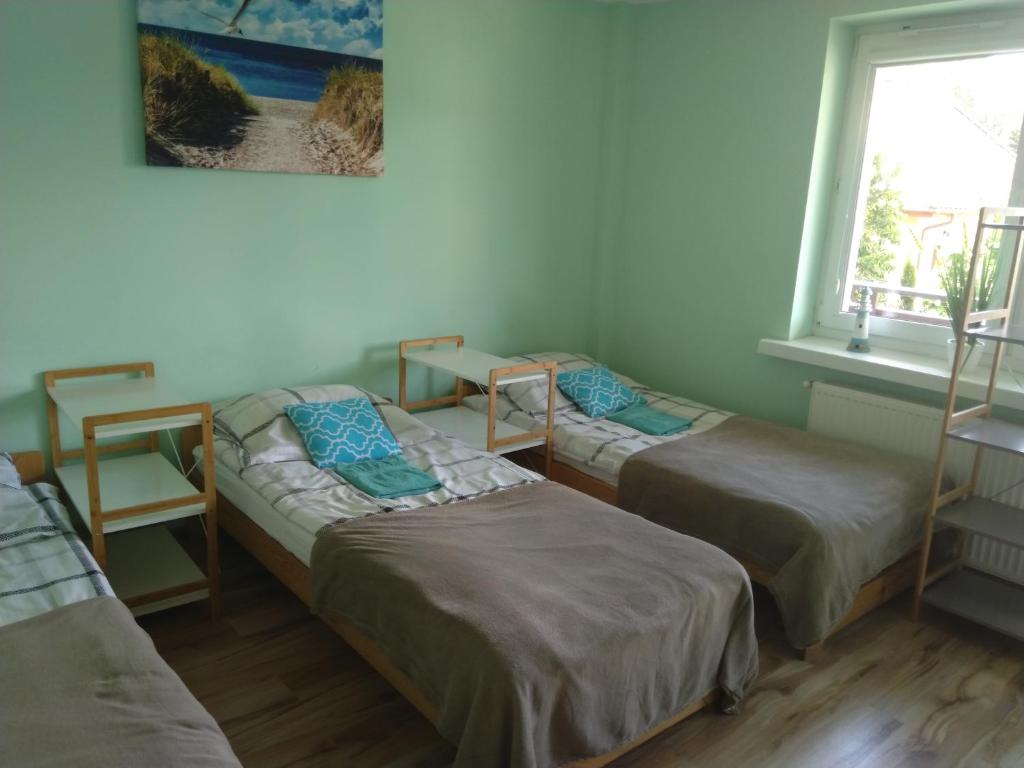 een kamer met 3 bedden en een raam bij Pokoje Gościnne Bajka in Rumia