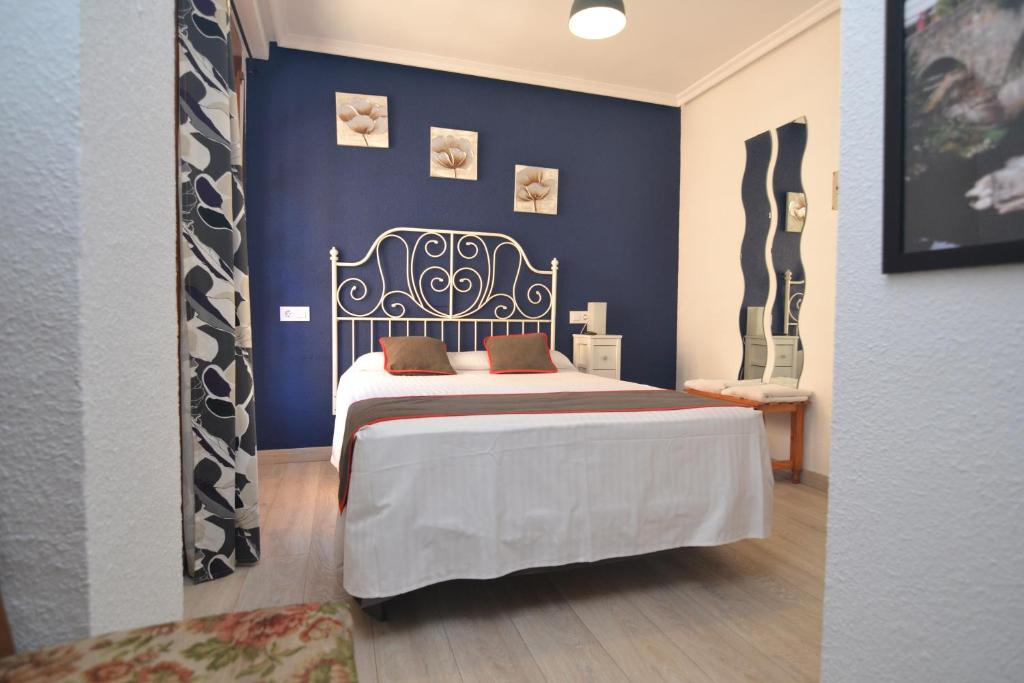 Hostería El Bodegón De Gredos في آريناس دي سان بيدرو: غرفة نوم بسرير مع جدار ازرق