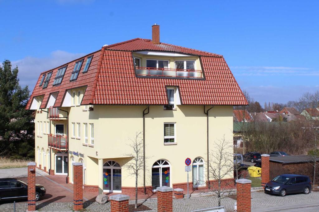 um grande edifício branco com um telhado vermelho em Ferienwohnung am Schloss em Ueckermünde